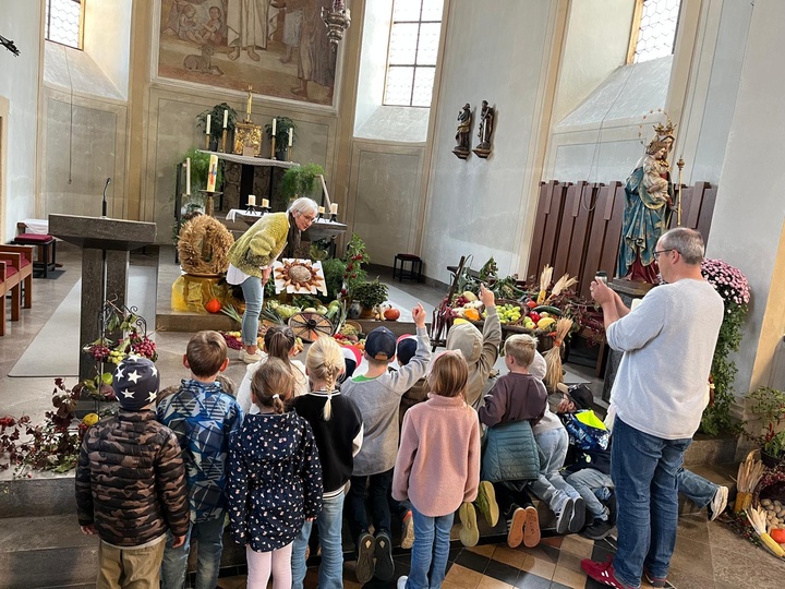 Kinder betrachten Erntegaben in der Kirche